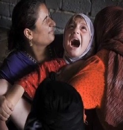 Picture of a girl with her mouth open, apparently gasping in pain, with her legs spread (although only one of them is visible), with one woman on each side of her.