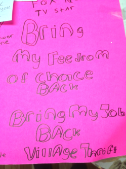 Picture of a banner made by Jenny Hatch. It reads, "Bring My freedom of choice back. Bring my job back -- Village Thrift".