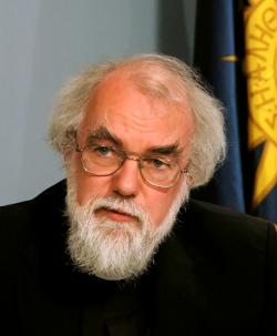 Picture of Rowan Williams, outgoing archbishop of Canterbury, a balding white man with a white beard, with a black robe and a barely visible white 'dog collar' insert