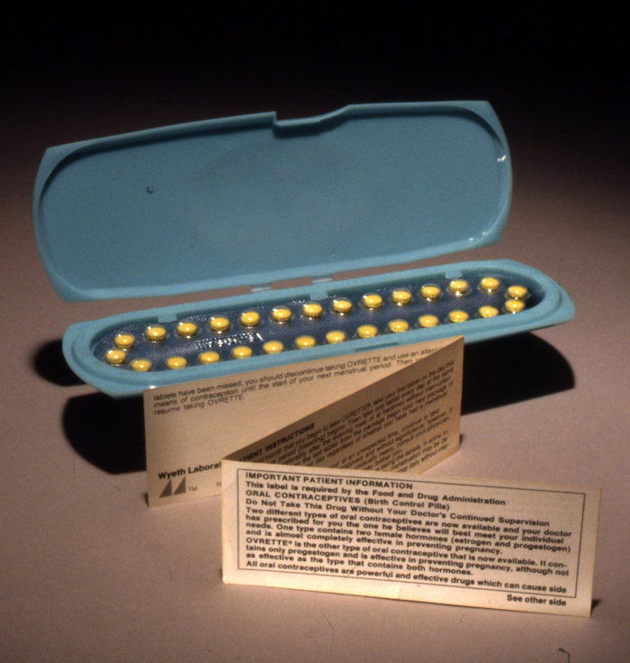 A picture of a blue packet with yellow pills arranged in an elongated oval shape, with a tri-fold insert with patient information on it.