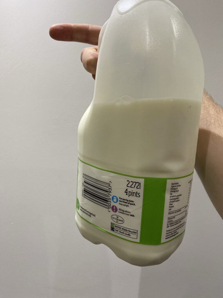A clear plastic four-pint bottle of milk with the metric measurement, 2.272 litres, given first, with a bar code and nutritional information on the label.