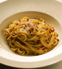 An image of spaghetti carbonara, containing spaghetti, cheese, pepper and bacon.