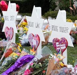 Three memorials to victims of the Tree of Life synagogue massacre, consisting of names (Daniel Stein, Melvin Wax and Irving Younger) written on white hexagonal stars, with flowers, hearts and stars placed at the feet of the stars, with the word "hope" visible on one of them.