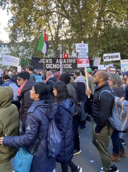 A picture of a demonstration for Palestine in London; banners include "Jews against genocide", "Jews for Justice for Palestinians", "not in our name" and a Palestinian flag.